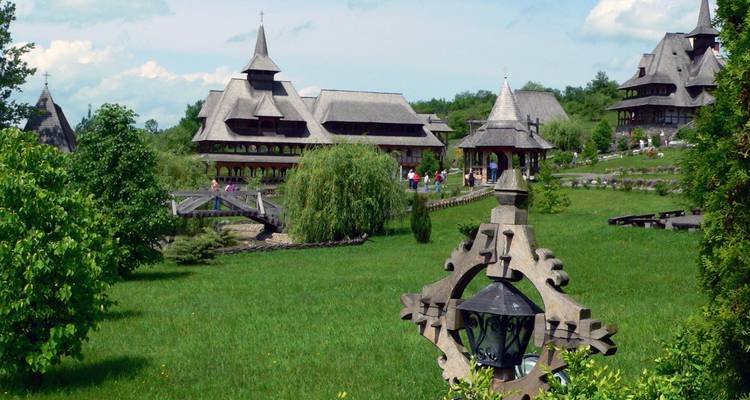 Traditionelle Holzgebäude mit Besuchern in einer grünen Umgebung.