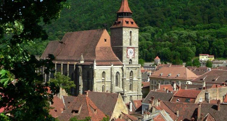 Blick auf eine historische Kirche mit Bergen im Hintergrund.