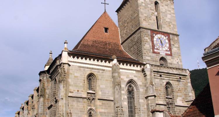 Historic church with a clock tower in an urban setting.
