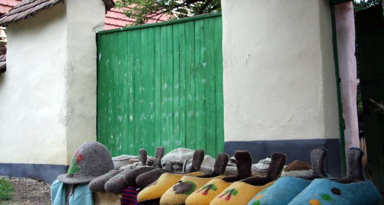 Colorful knitted hats displayed on a table outdoors.