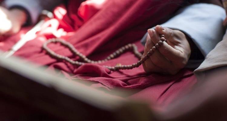 Gros plan d'une main tenant un chapelet.