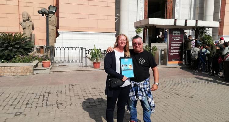 Deux personnes souriantes devant l'entrée d'un musée.