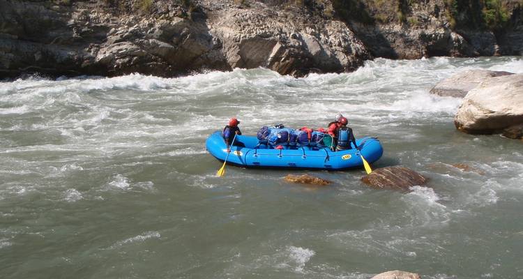 Deux personnes pagayant sur un radeau dans une rivière calme.
