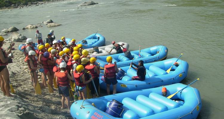 Rassemblement de groupe au bord de la rivière avec plusieurs radeaux.