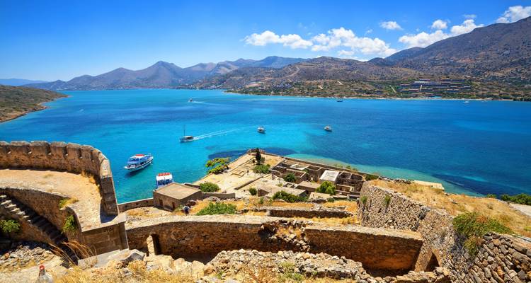Ruinas antiguas con vista a una laguna azul.