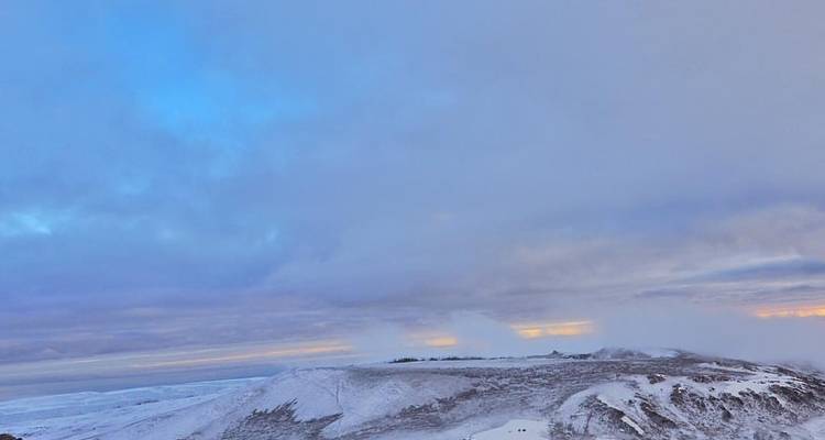 Snow-covered landscape with a distant horizon.