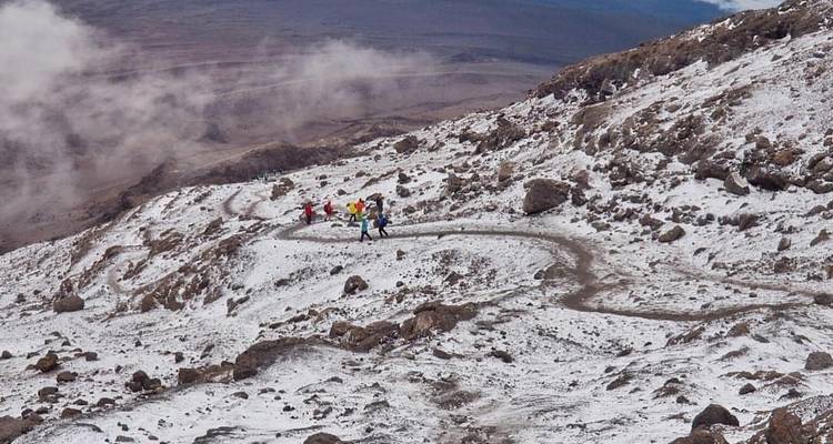 Icy mountain trail with hikers descending.