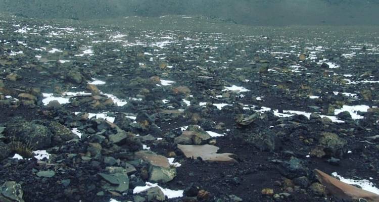 Rocky snow-dotted terrain under an overcast sky.