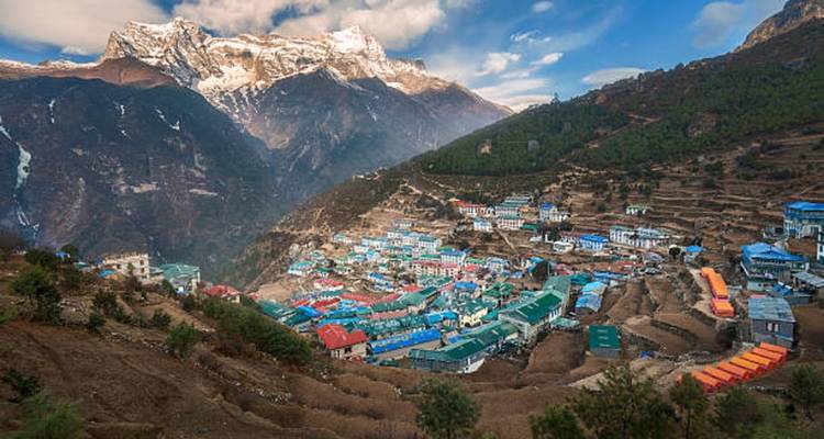 Une vue panoramique d'un village de montagne avec des sommets enneigés.