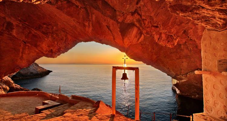 Eine Meereshöhle mit einer Glocke und einem atemberaubenden Sonnenuntergangsblick.