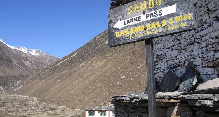 Signpost for Samdo and Larke Pass against mountainous backdrop.