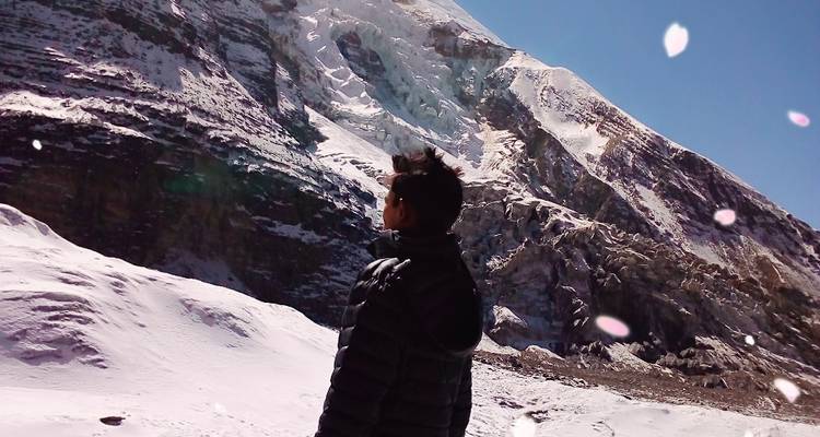 Einzelperson, die auf verschneite Berglandschaft blickt.