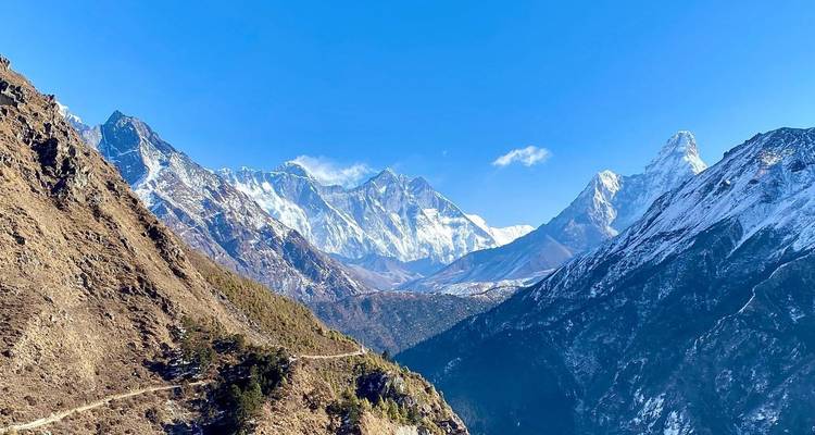 Chaîne de montagnes avec des sommets enneigés et un ciel bleu dégagé.