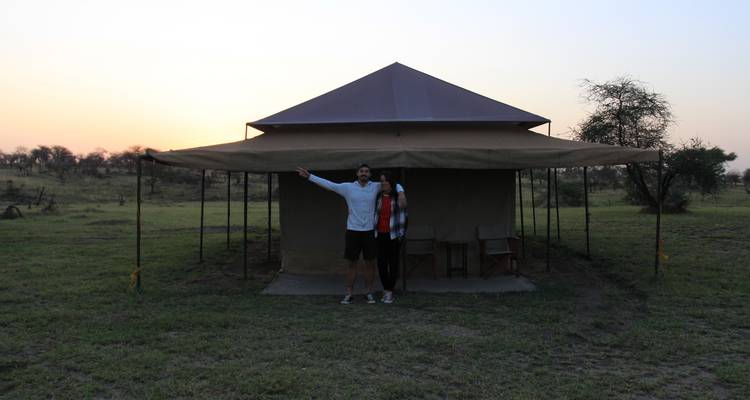 Couple posing in front of a tent at sunset.