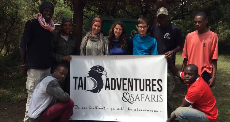 Group of people holding a banner for a safari tour.