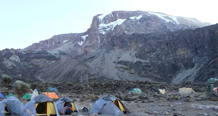 A mountainous campsite with tents set up in Tanzania.