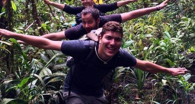 Drei Personen posieren verspielt in einer üppigen Dschungellandschaft.