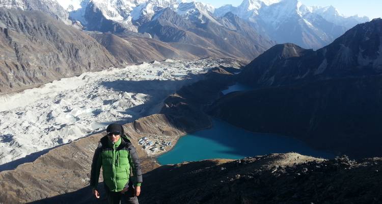 Person overlooking Gokyo Lakes from a high vantage point.