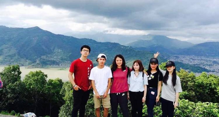 Gruppenfoto mit einer wolkenverhangenen Bergkette im Hintergrund.