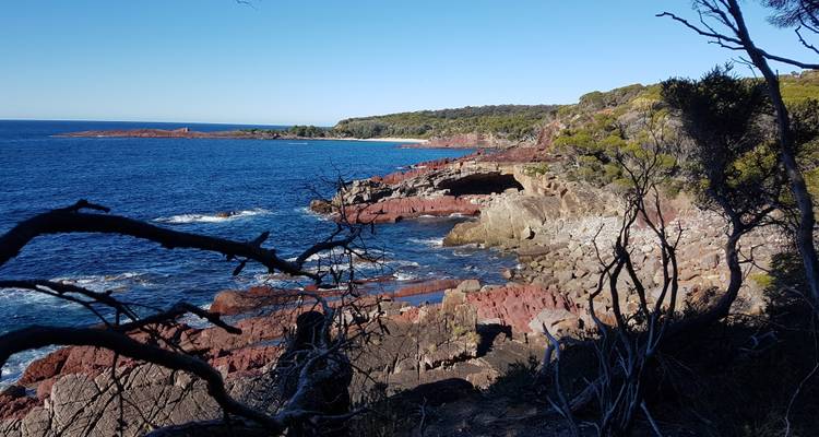 Felsige Küstenregion mit klarem, blauem Meer.