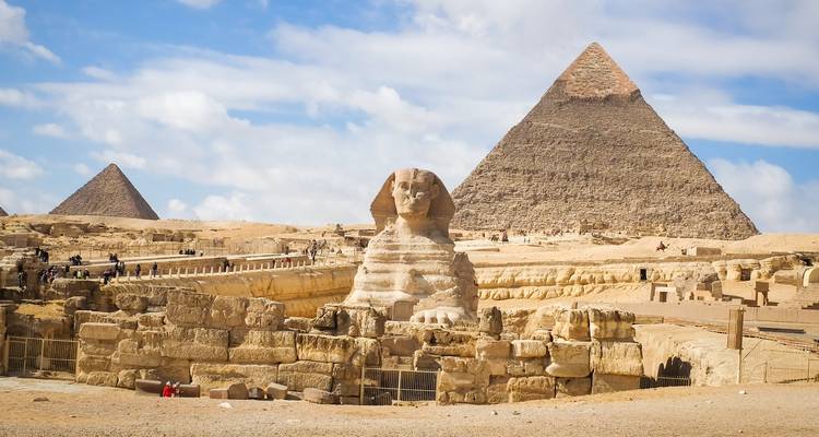 Sphinx and pyramids under a clear blue sky.