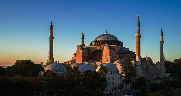 Large historic mosque at sunset with minarets.
