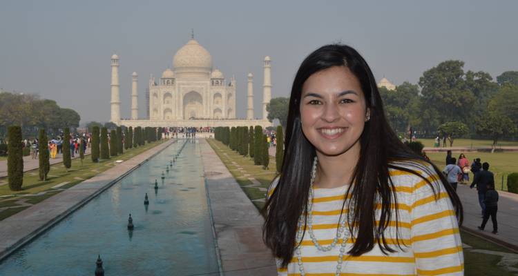 A woman smiling with the Taj Mahal in the background.
