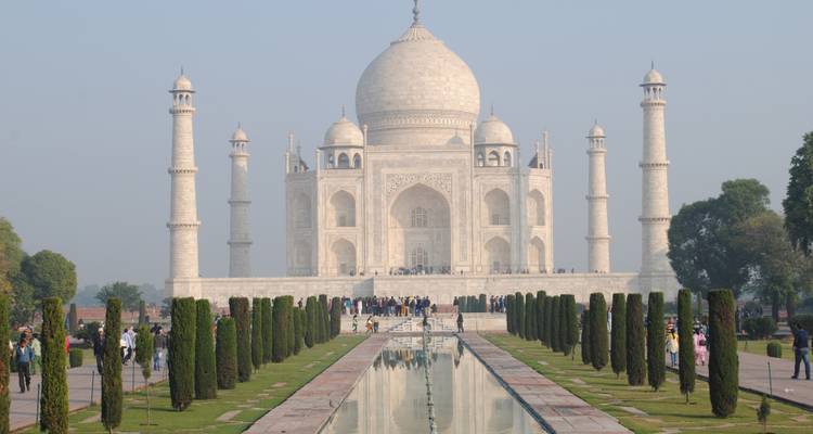 The Taj Mahal seen from a distance with people in the foreground.