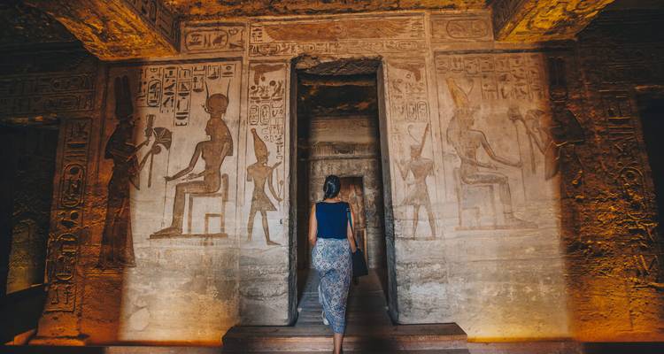 Une personne explorant un temple rempli d'hiéroglyphes.