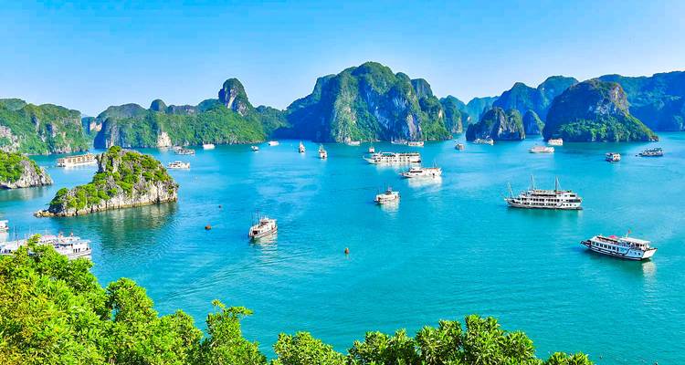 Boten in een blauwe baai omgeven door schilderachtige kalkstenen karsten.