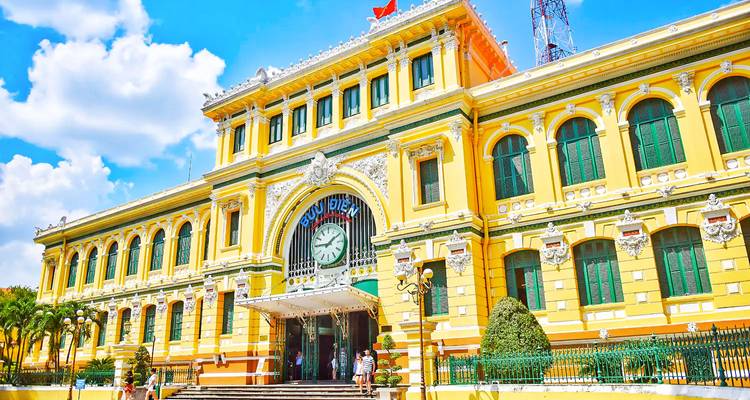 Een geel koloniaal postgebouw met een klokkentoren.