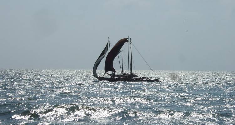 Barco de vela tradicional en mar abierto con agua centelleante.
