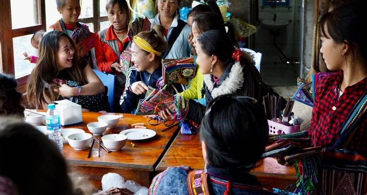 Eine Gruppe von Menschen, die drinnen gesellig beisammen sind und lachen.