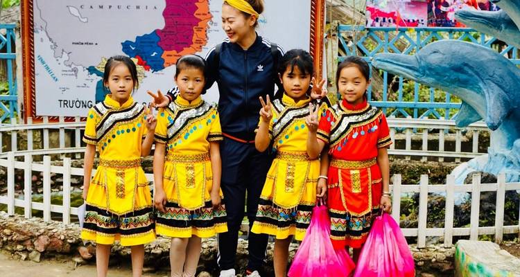 Eine Frau mit Kindern in bunter traditioneller Kleidung beim Posieren.
