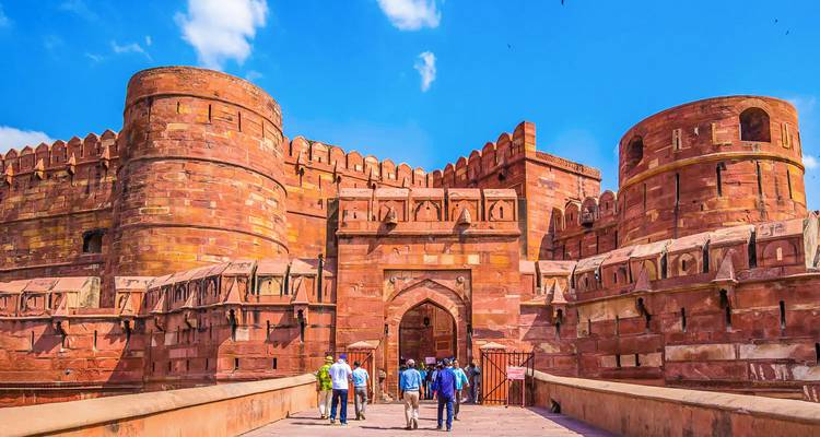 Mensen die een groot, rood fort binnengaan.