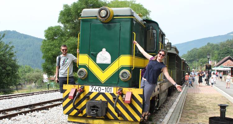 Un couple qui pose avec un train vintage en arrière-plan.