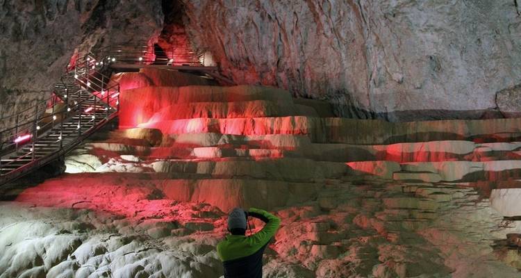 Personne prenant une photo à l'intérieur d'une grotte avec un éclairage rouge.