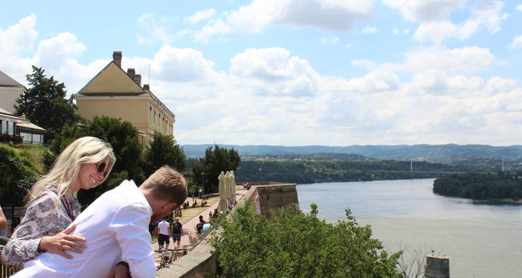 Couple profitant d'une vue depuis une forteresse surplombant une rivière.
