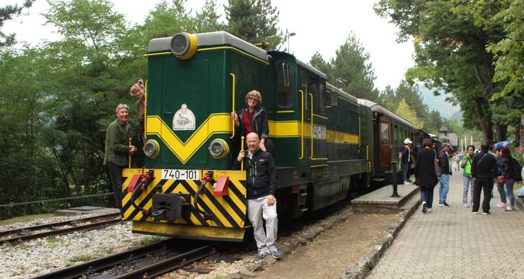 Des gens posant autour d'un train vintage dans une gare.
