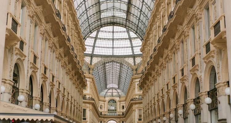 Intérieur d'une grande galerie marchande avec un plafond de verre.