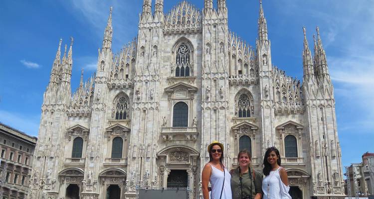 Groupe de femmes posant devant la cathédrale de Milan par une journée ensoleillée.