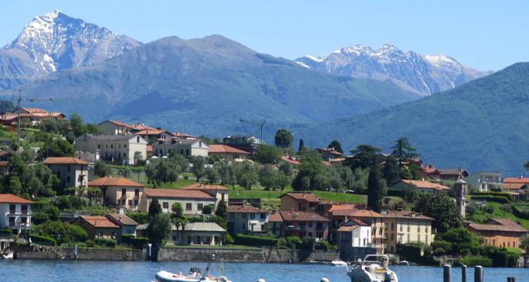 Vue pittoresque d'un village au bord d'un lac avec des montagnes.