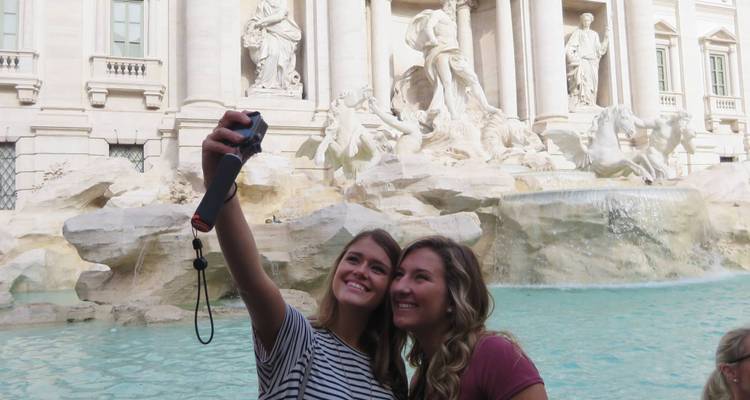 Deux femmes prenant un selfie devant la fontaine de Trevi.