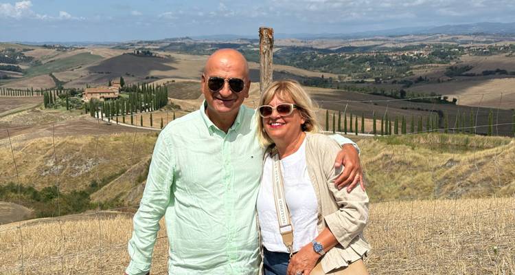 Couple posant avec une belle vue panoramique de la Toscane.