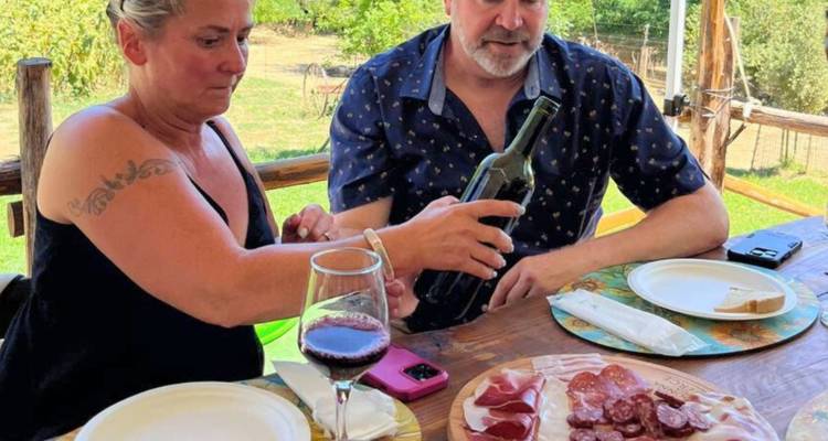 Couple profitant de vin et plateau de charcuterie en plein air.