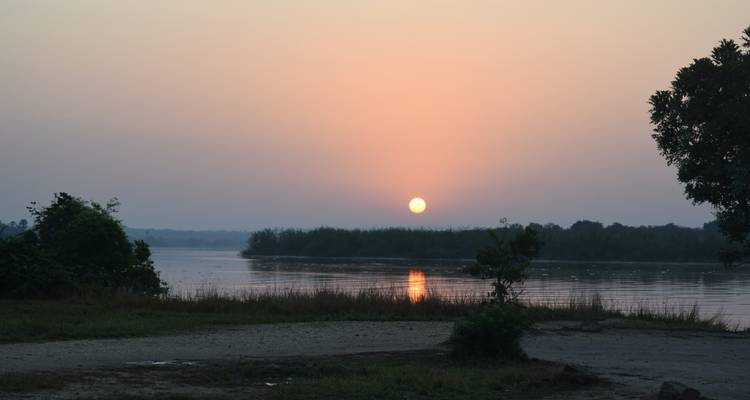 Zonsondergangzicht over een kalme rivier.
