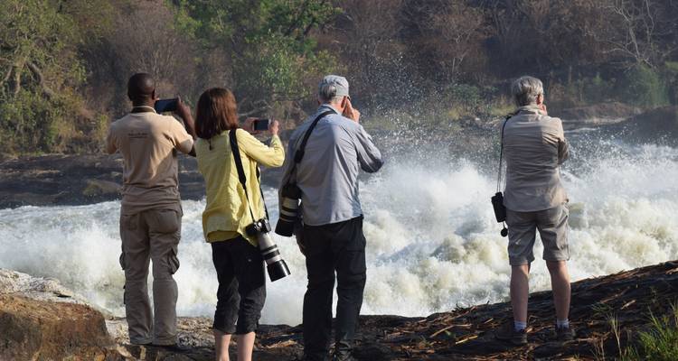 Bezoekers die foto's maken bij een rivier.