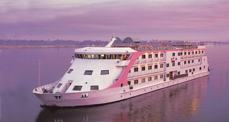 Un bateau de croisière naviguant sur le Nil au coucher du soleil.
