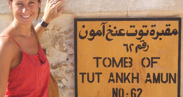 Personne posant à côté d'un panneau pour le tombeau de Toutânkhamon.