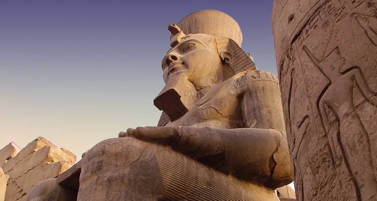 Gros plan d'une grande statue antique avec des hiéroglyphes sur une colonne.